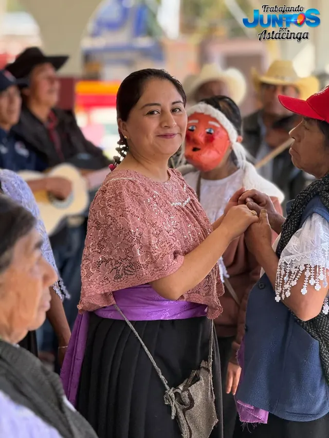 Danza tradicional en la vía pública, con danzantes enmascarados y músicos de la comunidad.