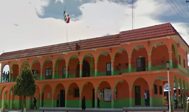 Fachada del Palacio Municipal de Astacinga, edificio de dos niveles con arcos y bandera de México.