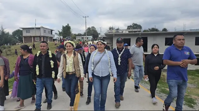 Recorrido de autoridades y habitantes por una calle pavimentada del municipio.