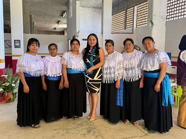 Grupo de mujeres con blusas bordadas y faldas negras, indumentaria tradicional de la región.