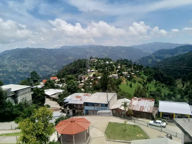 Vista aérea de la cabecera de Astacinga, con viviendas sobre la ladera y la sierra al fondo.